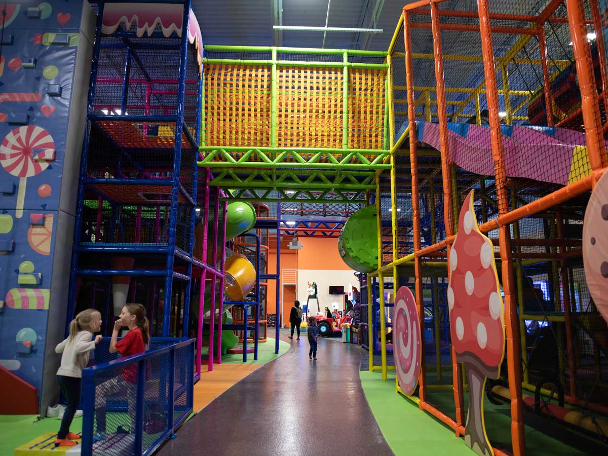 indoor big play structure with two girls laughing