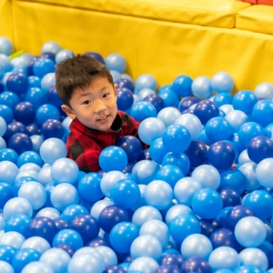 boy having fun in an indoor ball pit