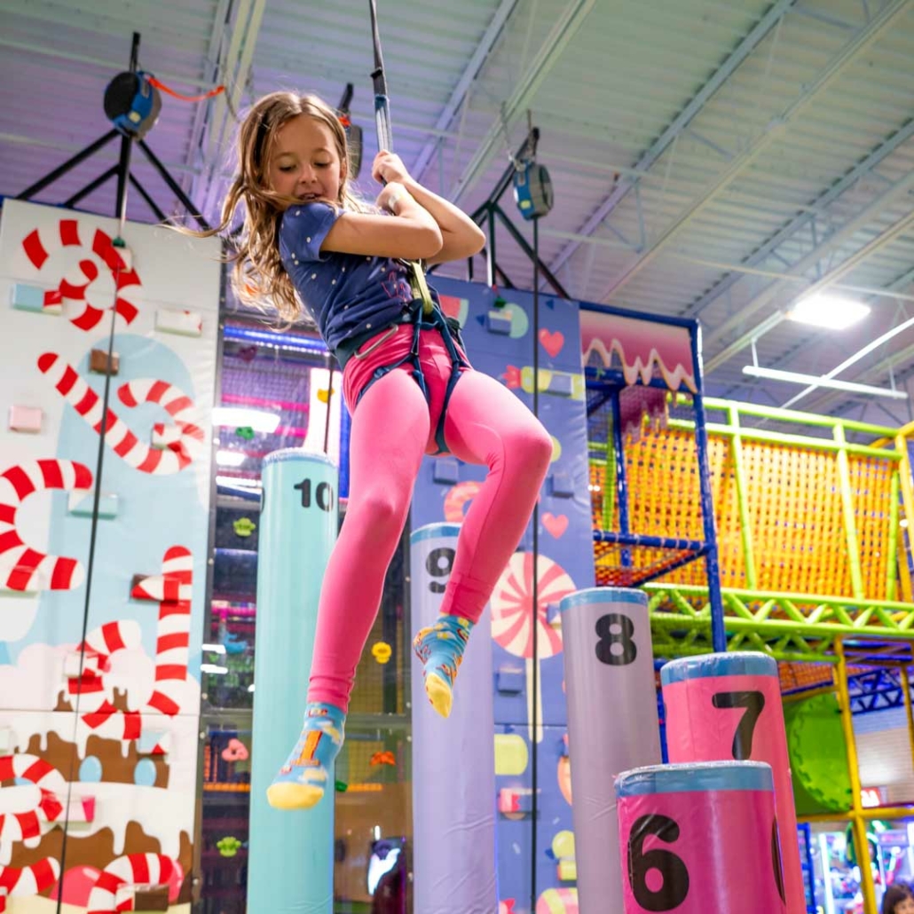 a girl repelling down a climbing wall at a party venue