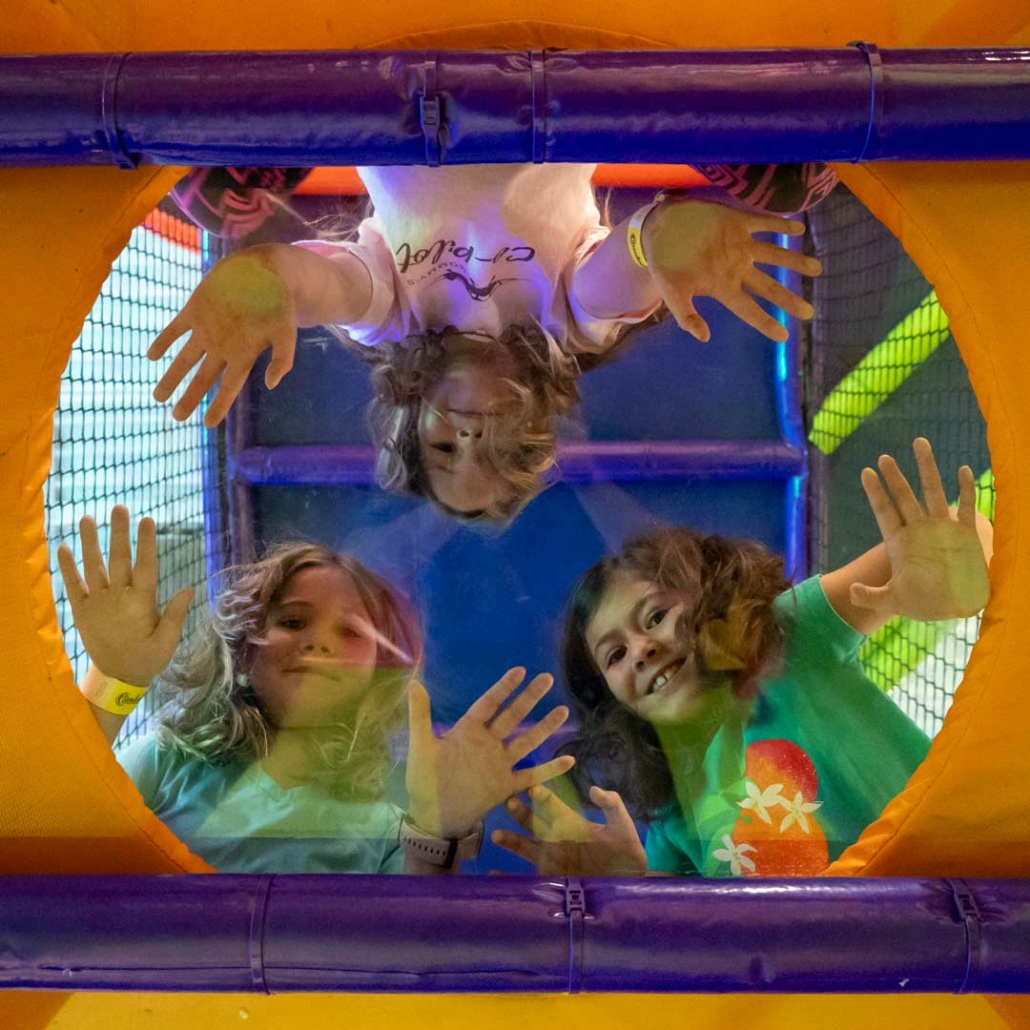 three girls looking down from indoor playhouse